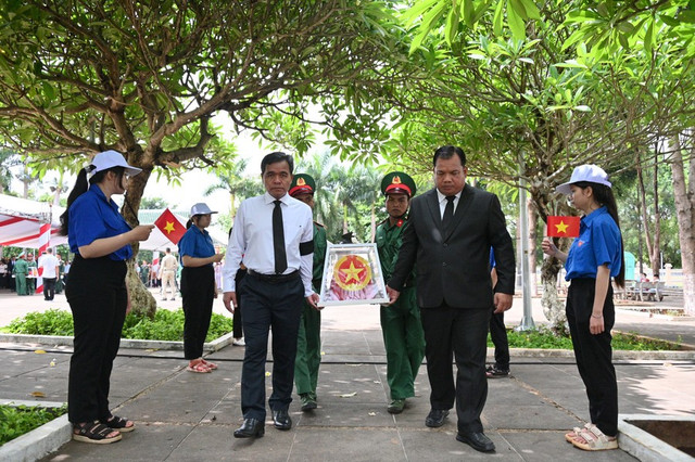 Bí thư Tỉnh ủy Gia Lai Hồ Văn Niên và đại diện lãnh đạo tỉnh STung Treng tiễn đưa hài cốt liệt sĩ về nơi an táng. Ảnh: Đ.T/GLO liet-sy.jpg
