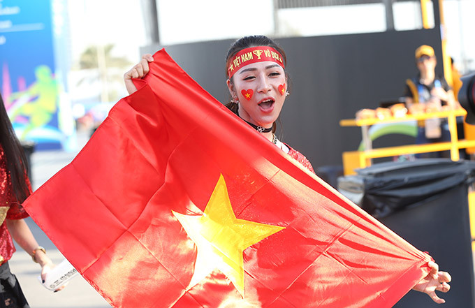 Cô gái xinh đẹp gây chú ý với dòng chữ "Việt Nam vô địch" quấn ở trên đầu và tay giơ cờ tổ quốc