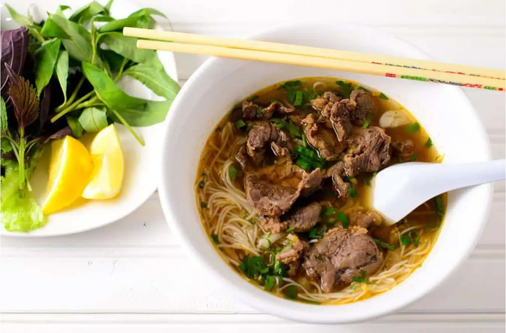 Nhắc đến Huế, người ta nghĩ ngay đến món bún bò cay nồng, đậm đà. Một tô bún bò mang nhiều hương vị khác nhau đến từ các gia vị, rau nêm như mùi sả, nước hầm xương, chanh, tiêu,... Ảnh: Traveloka