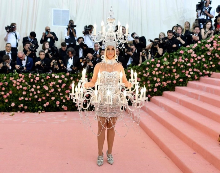 Một thiết kế "điên rồ" nữa phải kể đến là chiếc váy đèn chùm của Katy Perry. Katy Perry đã hóa thân thành bộ đèn chùm tại Met Gala 2019. Nó được bao trùm với pha lê Swarovski, nặng gần 20 kg và gây khó khăn trong việc di chuyển của nữ nghệ sĩ.