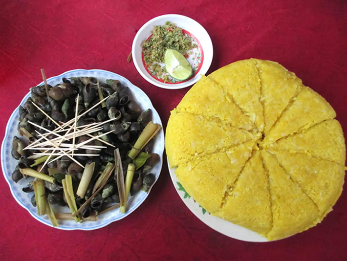 Cơm bồi Minh Hóa là món ăn bình dân phổ biến tại Quảng Bình. Cơm bồi được làm từ hạt ngô và sắn tươi, thường được ăn cùng với ốc đực bắt từ suối và cà lào. Ảnh: @tuhaoviet.vn
