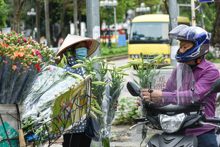 Dù vội đến mấy nhiều người vẫn sẵn lòng dừng chân ghé lại những gánh hoa ven đường để chọn mua vài cành loa kèn đầu mùa thật đẹp.