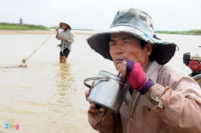 Người dân tranh thủ ăn trưa (cơm nấu ở nhà mang theo) ngay trên ghe máy neo giữa sông để tiếp tục công việc.