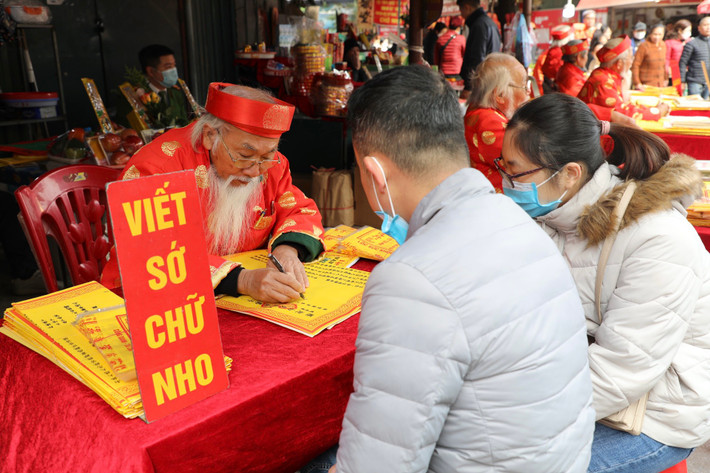 Du khách viết sớ ở cổng phủ trước khi vào làm lễ.