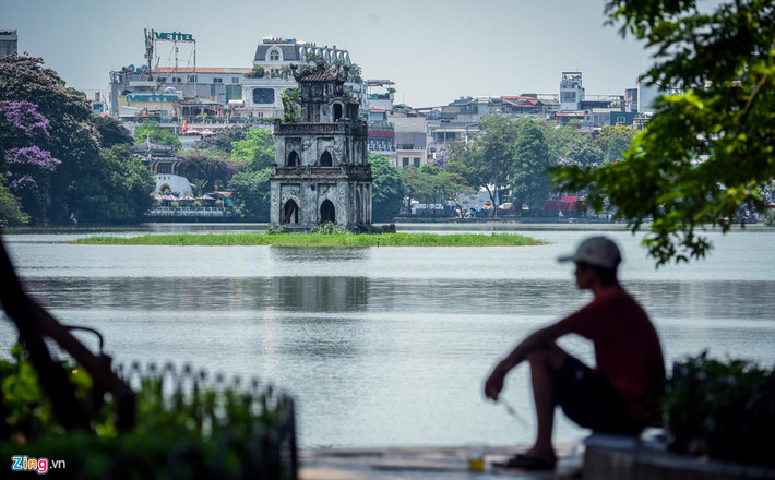 Người dân tranh thủ nghỉ ngơi, hóng mát ven Hồ Gươm.