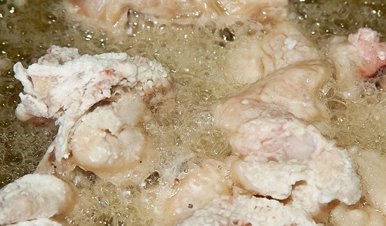 Cà rốt gọt vỏ tỉa hoa cho đẹp, hành củ lột bỏ vỏ để nguyên, hành lá và ngò nhặt bỏ rễ lá sâu, tất cả rửa sạch để ráo. Bắt nồi nước lên bếp, nước sôi bỏ tí muối vào, rồi cho thịt đùi gà, chân gà vào trụng sơ. Sau đó rửa lại thịt gà này cho đi bọt bẩn. Ảnh: Cacmelamdep.com.
