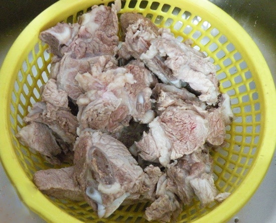 Khi nước dùng xương đã được, vớt xương ống để riêng, cho cà chua, khế, mẻ và đầu cá hói vào đun sôi nhỏ lửa. Cá hói cắt khúc dày khoảng 2 - 3cm, ướp cá với bột canh, bột nêm, vài lát ớt. Ảnh: Cooky.vn.