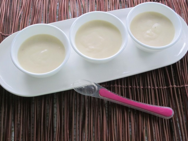Cho sữa tươi, sữa bột vào nồi và đun sôi trên lửa nhỏ, khuấy đều. Khi sữa nóng thì cho vào hỗn hợp chuối và kem tươi vào nồi, trộn đều và tiếp tục nấu cho đến khi váng sữa sền sệt lại thì tắt bếp. Đổ váng sữa ra bát. Đợi khi váng sữa nguội và chuyển sang ngăn mát tủ lạnh để bảo quản. Ảnh: mevacon.com.vn.