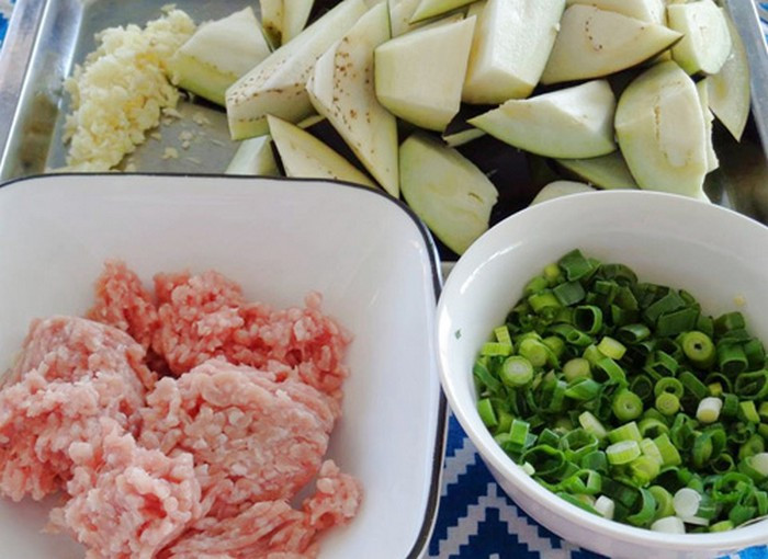 5. Cà tím xào tỏi. Nguyên liệu gồm cà tím, thịt nạc băm, hành lá. Cà tím rửa sạch lau khô và nướng nguyên trái trên bếp cho cà sém vỏ rồi cắt đôi. Thịt băm đem ướp với hành và các gia vị khoảng 10 phút. Rửa sạch hành lá và thái thật nhỏ. Ảnh: Tin247.