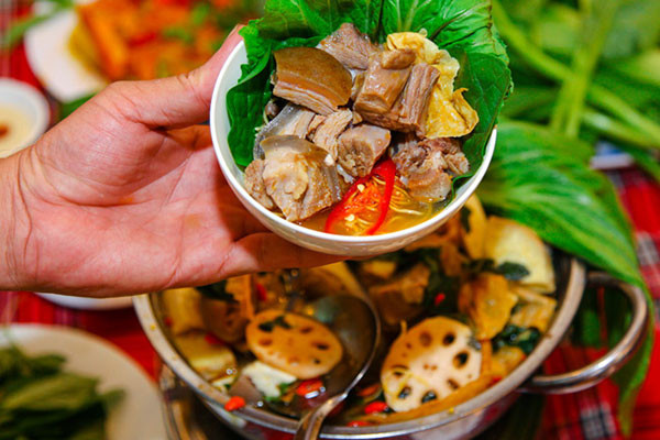 Sau khi đun sôi 10 phút tiếp tục cho khoai môn và củ sen vào đun với lửa nhỏ trong 15 phút, nêm nếm gia vị cho vừa miệng rồi tắt bếp. Nước dùng dê vừa chuẩn bị ở trên trút hết vào nồi lẩu sau đó đặt lên bếp, bạn có thể chuẩn bị bếp gas mini hoặc bếp điện để ăn lẩu. Những nguyên liệu ăn lẩu: rau nhúng, đậu phụ, váng đậu, nấm được chuẩn bị và dọn ra xung quanh nồi lẩu. Ảnh: phunudep.com.