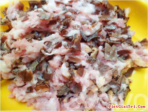 Nấm hương mộc nhĩ thái nhỏ, thịt xay trộn chung và 1 thìa nước mắm, tiêu, hành thái nhỏ. Nhồi thịt và nấm vào bao tử cá, ta dùng chiếc đũa nhồi nhân cho kín. Ảnh: vietgiaitri.com.