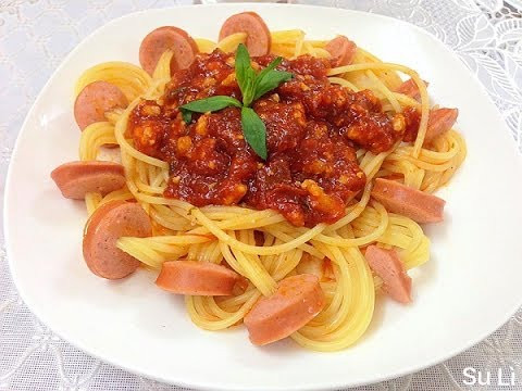Đun nước sôi và thả mỳ vào trần qua. Cho dầu vào và phi tỏi thật thơm lên. Sau đó cho tiếp hành tây đã băm nhuyễn vào đảo cùng. Tiếp theo cho xúc xích vào rồi đổ sốt cà lên. Cho ngay mỳ vào, đảo lên, th.m gia vị vừa đủ, độ 5-10 phút là được. Lúc bắc ra nhớ rắc hạt tiêu cho thơm. Ảnh: youtube.com.