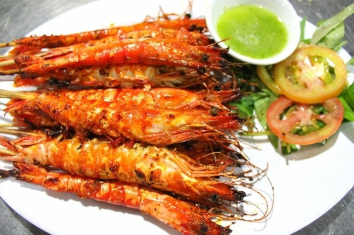 Các nguyên liệu giã nhuyễn rồi phi thơm cùng dầu ăn, thêm mắm ruốc vào đảo, rồi cho nước cốt dừa vào chung. Thêm nước vào rồi nấu sôi, nêm nước mắm, muối, đường sao cho hợp khẩu vị. Cho tôm đã bóc vỏ vào nấu chín. Cuối cùng cho nước cốt chanh, húng quế trộn lên cho thật đều. Món này dùng nóng với cơm hoặc bánh mì. Ảnh: banhtranghubinh.com.