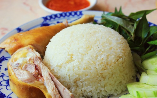Sau đó cho gà, lá dứa và hành tím vào. Đổ nước ít hơn khi nấu cơm mỗi ngày vì gà sẽ ra nước. Sau đó bật cook để nấu. Cơm chín là gà sẽ vừa chín tới. Pha nước tương, dầu hào, đường và tỏi ớt băm để làm nước sốt ăn kèm. Ảnh: Ngonngon.