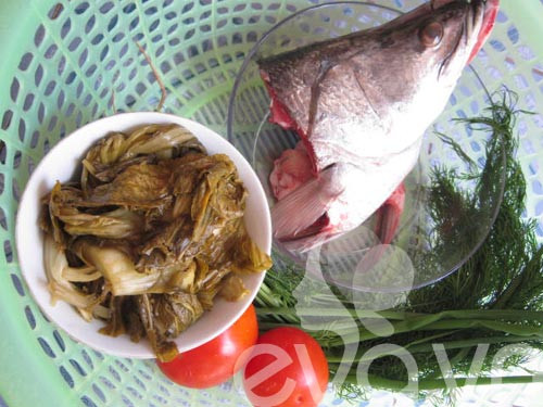 3. Đầu cá vược nấu dưa chua. Nguyên liệu: Đầu cá vược, dưa chua, cà chua, hành hoa, hành khô, gừng, tỏi, ớt, hạt nêm. Cá vược cắt lấy đầu rửa sạch, bổ đôi rồi ướp cùng một rượu và hạt nêm. Cho đầu cá vào chảo dầu đã sôi để rán vàng đều các mặt. Hành, tỏi, gừng bóc vỏ, rửa sạch và băm nhỏ. Sau đó phi thơm trong chảo dầu nóng. Ảnh: eva.vn.