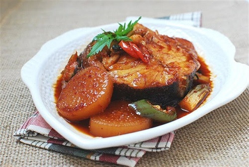 Cá làm sạch, thái khúc, ướp muối, để ráo, rán vàng. Xếp cá vào nồi, cho tiếp củ cải, đường, tiêu, hành, nước đậy vung đun nhỏ lửa tới khi củ cải mềm, nước hơi cạn là được. Ảnh: 7monngonmoingay.info.