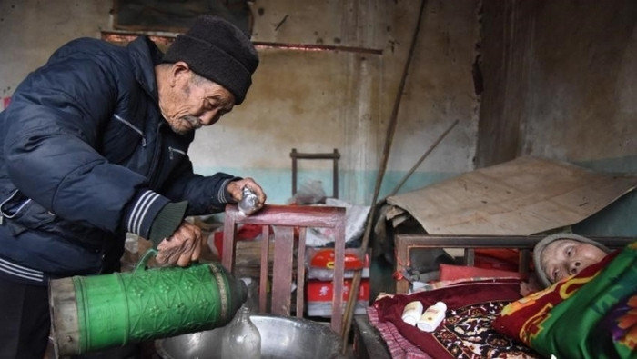 56 năm chăm sóc vợ trên giường bệnh. Chỉ 5 tháng sau khi kết hôn, bà Zhou bất ngờ bị liệt và cơ thể không cử động được. Từ đó đến nay bà đã nằm trên giường bệnh 56 năm. Ông Du tự làm tất cả mọi việc, từ sắc thuốc cho tới việc cho vợ đi vệ sinh. Nhiều người bạn đã khuyên ông Du nên đi tìm một người vợ khác để bắt đầu một cuộc sống mới, nhưng ông đã không làm như vậy. Ảnh: Elitedaily.