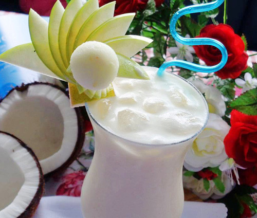 Rót sinh tố dừa tươi ra ly, chia đôi phần thạch dừa ra 2 ly sinh tố, cho thêm đá bào vừa đủ dùng lên trên, rưới vài đường sữa đặc chéo nhau trên đá bào cho đẹp mắt. Gắn lát chanh tươi lên thành ly sinh tố dừa tươi. Ảnh: eva.vn.