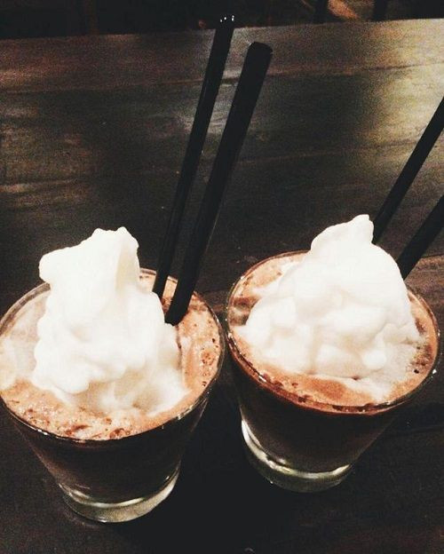 Khi cà phê chảy hết bạn thêm sữa và nước dừa vào. Cũng có thể biến tấu thêm cả nước cốt dừa và dừa nạo vào để thức uống thơm ngon và lạ. Cho đá viên vào ly và rót cà phê nước dừa vào, rắc lên trên 1 chút ca cao. Ảnh: blog.beemart.vn.