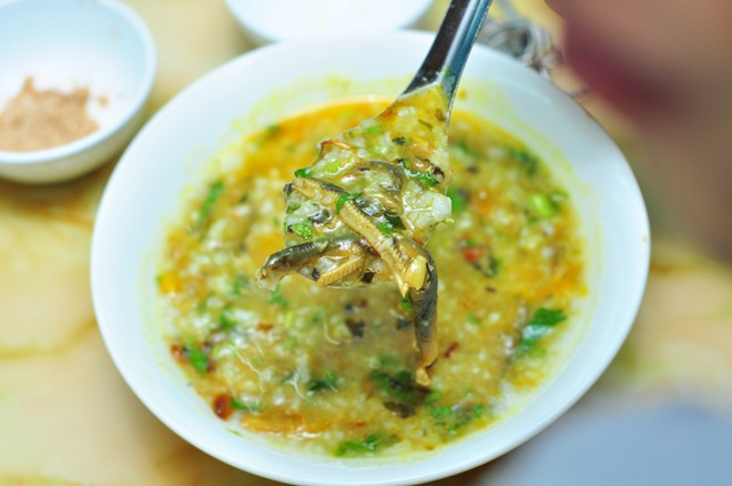 Sau đó cho nước nắm, muối, mì chính vừa ăn, đảo 1 lúc nữa rồi tắt bếp. Múc cháo vào tô, cho đậu phụ chiên, lươn xào, hành phi, rau ngổ lên trên rồi thưởng thức. Ảnh: phunutoday.vn.