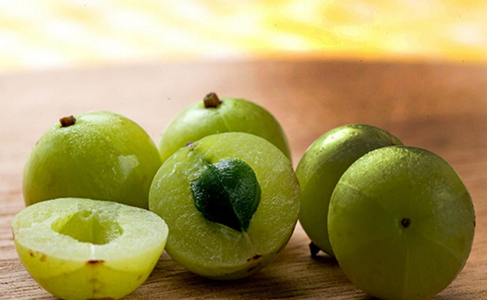 Quả amla và dầu dừa. Dùng quả dâu Ấn Độ (amla) hấp cùng dầu dừa và thoa lên da đầu của bé. Hoặc có thể dùng nước ép quả này làm dầu gội đầu. Ảnh: Phunuonline.