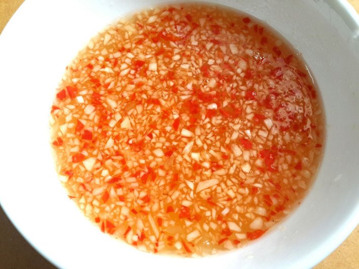 Thịt ba chỉ luộc chín với nước dừa, muối, củ hành. Thịt chín vớt để nguội rồi cắt mỏng. Vẫn nồi nước luộc thịt cho tôm vào luộc vừa chín tới vớt ra để nguội, lột vỏ, bỏ chỉ đen. Nước trộn gỏi: đường, chanh, nước mắm, tỏi, ớt. Trộn thịt và tôm vào 1 cái tô cho 1 nửa nước trộn gỏi vào trộn đều cho thấm khoảng 10 - 15 phút. Ảnh: bepgiadinh.com.
