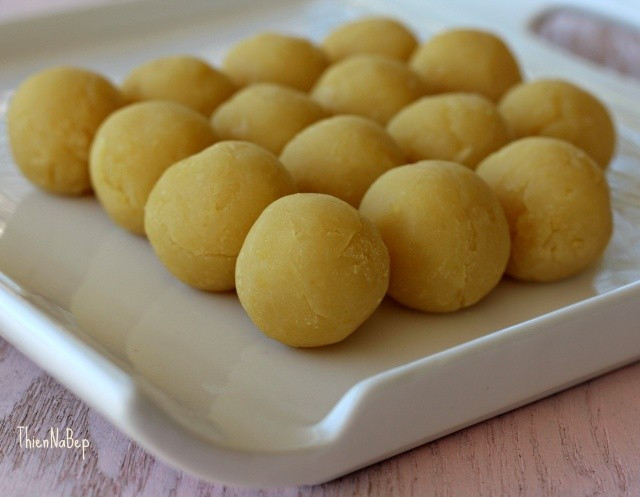 Tiếp đó cho bột bánh dẻo đã được hòa tan vào tiếp tục sên cho đến khi đậu xanh quyện thành từng khối thì mới cho nước hoa bưởi vào. Lưu ý, đảo luôn tay để tránh bị cháy, khê. Đợi nhân nguội thì vo lại thành từng viên nhỏ. Ảnh: Fud.vn.