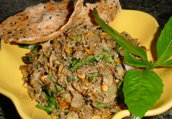 4. Rắn xúc bánh đa: Vàng giòn màu nghệ, thơm lừng mùi tỏi, sả, ớt. Rắn được bằm hoặc xay nhuyễn, tỏi khử, xào rắn trên lửa lớn đều. Lá chanh và lá điều non thái mỏng, rải đều trên mặt. Ăn kèm với món này có bánh đa hoặc bánh phồng tôm chiên. Ảnh: Saigongame.com.