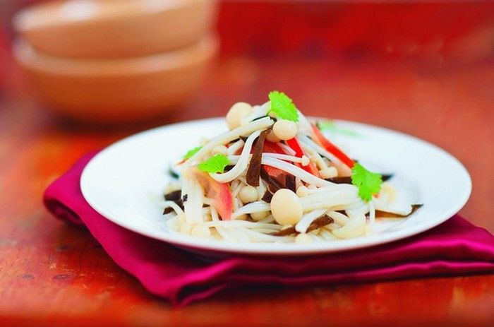 Cho nấm kim châm mộc nhĩ, và cà chua vào một chiếc tô lớn cho thêm gia vị rồi trộn đều sau đó cho thêm 3 thìa giấm gạo, rưới thêm 2 thìa dầu mè vào và trộn đều salad. Bạn có thể thêm một số gia vị yêu thích của bạn như: bột nêm, bột gia vị thịt, ớt tùy vừa miệng ăn. Ảnh: Bepnha.