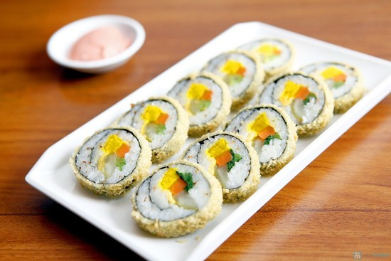 Cuộn tròn kimbap, cắt kimbap ra thành những khoanh 1,5 cm. Nhúng phần ngoài của kimbap vào trứng rồi lăn qua bột chiên xù, chiên cho đến khi lớp vỏ bên ngoài có màu vàng rụm. Kimbap vàng, cho ra ngoài bày trí và ăn kèm với dưa chuột. Ảnh: sinhvienvietnam.edu.vn.
