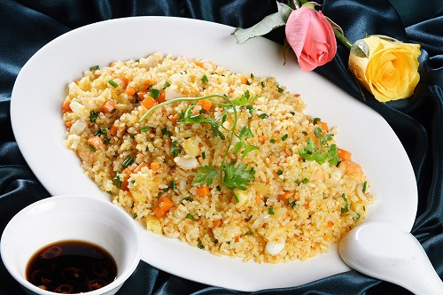Sau khi cá vàng đều, cho cơm vào đảo 5 phút rồi nêm gia vị. Cuối cùng cho trứng gà đã quấy đổ vào chảo và đảo đều tay. Khi cơm đã se lại, vàng đều thì các bạn rắc hành lá, tiêu vào và tắt bếp. Ảnh: PhunuNet.com.