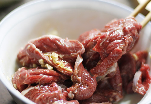 5. Thịt bò nướng ống tre. Nguyên liệu: Thịt bò, rau ngổ, tiêu xanh, hành khô, mùi tàu, gia vị, tỏi. Dụng cụ: Ống tre, than hoa. Thịt bò rửa sạch ướp cùng mắm, tiêu, đường, hành, tỏi, hạt nêm. Cho thịt bò vừa ướp vào ống, cho tiếp rau xanh, tiêu xanh và sả vào ống. Ảnh: thegioinoitro.vn.