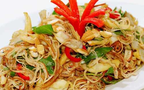 Cho bắp chuối, hành tím, ớt chuông vàng và đỏ, cần tây, ớt sợi, đậu hũ ky vào tô, rưới nước mắm vào trộn đều cho thấm gia vị, thêm hạt điều vào trộn. Ảnh: cacmonchayngon.net.