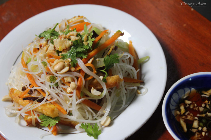 Phi thơm hành, thêm phần nấm tàu hũ ky, cà rốt, cần tây, vào đảo cho đều tay. Xào như vậy khoảng 3 phút thì thêm phần đậu hũ chiên và hỗn hợp nước tương đã pha vào. Tiếp đến là nêm sa tế rồi cho tiếp bún vào xào chung, đảo đều là món ăn đã hoàn thành. Ảnh: yeunoitro.net.