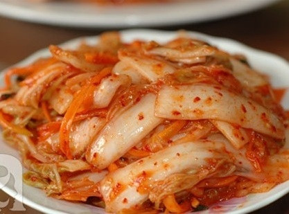Đeo găng tay và trộn đều cho đến khi gia vị bám đều cải thảo. Sau đó cho kim chi vào những lọ thủy tinh sạch, ép xuống cho đến khi nước muối phủ lên kim chi, dùng vật nặng nhỏ để nén xuống cho kim chi không bị nổi lên. Đậy nắp lại. Để bình kim chi ở nhiệt độ phòng từ 1-5 ngày. Ảnh: cachlam9.com.