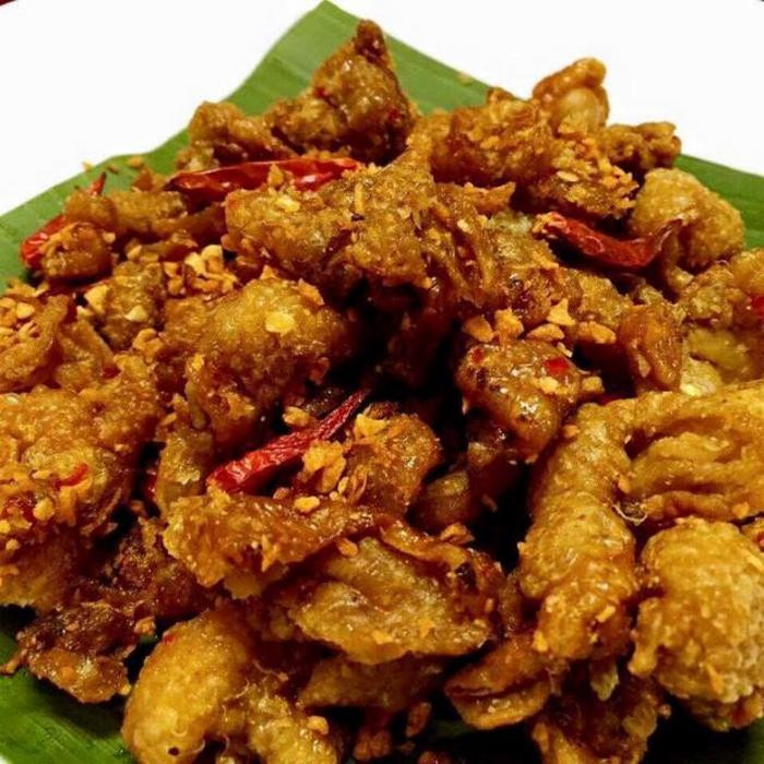 Bắc chảo lên bếp, cho dầu ăn chiên da gà ngập dầu trên lửa lớn. Sau đó, vớt da gà ra để ráo mỡ. Sau đó phi thơm tỏi và cho nước sốt đã pha vào đảo đều rồi cho da gà vào nấu cho đến khi keo lại sền sệt là được. Ảnh: Cahlammonngon.