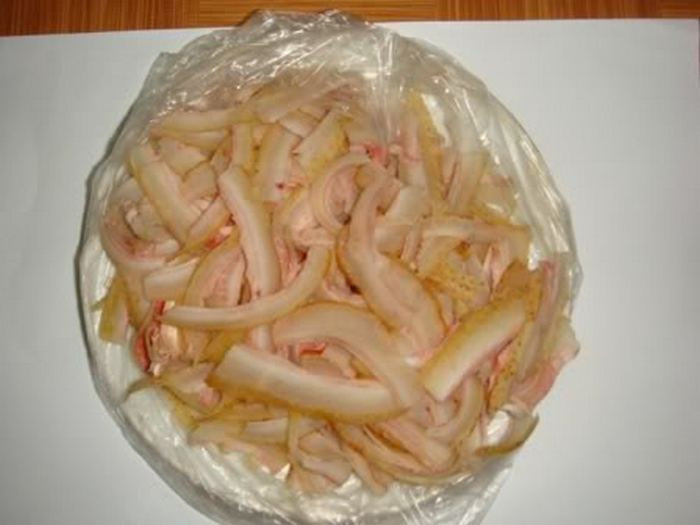 3. Da bò xào nghệ. Món ăn từ da bò nổi tiếng ở vùng Hóc Môn, Củ Chi này đã ăn một lần là nhớ mãi không thể nào quên. Nguyên liệu chính là da bò tơ và sả, nghệ, gia vị, nước dừa tươi. Đầu tiên, da bò được thui vàng ươm rồi dùng dao cạo thật sạch. Sả để cả cây bó lại và đập dập chà xát bên ngoài lớp da để khử mùi hôi và tạo mùi thơm. Ảnh: Lamchame.