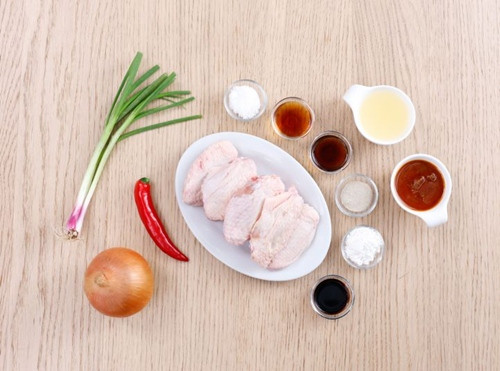 4. Cánh gà chiên sốt hành tây. Nguyên liệu: Cánh gà, hành tây, bột bắp, nước tương, tiêu, rau sống, dưa leo, nước mắm. Chần qua cánh gà. Chần xong, giấy thấm khô, nếu muốn thì lấy tăm châm xung quanh cánh gà để ướp cho thấm. Ảnh: Eva.vn.