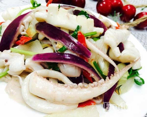 Cho cà chua thái múi cau vào xào tầm 1 phút, sau đó cho mực vào đảo ở lửa to. Nêm chút nước mắm. Mực bắt đầu hơi chín thì cho hành tây thái múi cau vào. Xào tầm 1 phút thì cho tiếp giá. Nêm nếm lại vừa ăn. Giá mềm thì tắt bếp. Cho thì là và hành lá vào đảo 1 lượt rồi múc ra đĩa. Rắc chút hạt tiêu lên và thưởng thức. Ảnh: VietNamNet.vn.