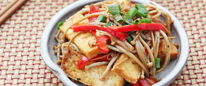 Phi thơm hành, tỏi băm và cho đậu phụ vào đảo qua, cho cà rốt, nấm, vào đảo nhanh tay trên lửa lớn, nêm thêm gia vị vừa miệng. Khi các nguyên liệu vừa chín tới thì cho giá vào xào qua. Cuối cùng cho hành mùi và rắc hạt tiêu lên trên. Ảnh: Cachnauanngon.