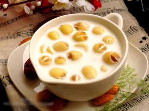 Lấy một cái nồi khác, đun sữa ấm lên là được, không cần phải đun sôi. Cho sữa và bột hạnh nhân vào nồi hạt sen, khuấy đều cho bột hạnh nhân tan hết rồi tắt bếp. Ảnh: bepgiadinh.com.