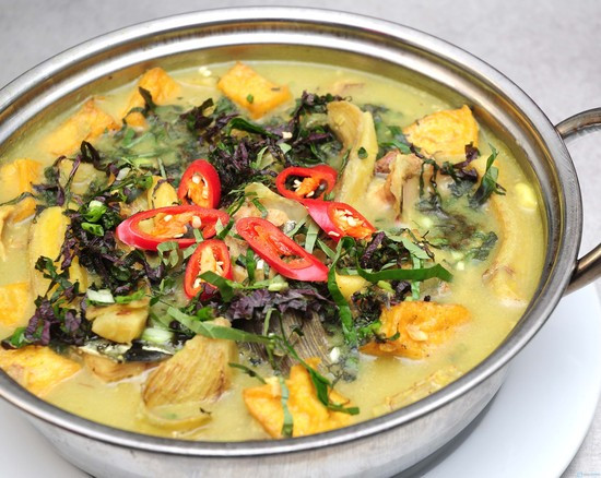 Phi thơm hành tỏi băm với ớt bột rồi cho ốc bươu vào xào nhanh tay, ốc vừa chín tới, bạn trút ra đĩa, để riêng; Phi thơm dầu ăn với phần hành tỏi còn lại và ớt bột để món ăn có màu sắc hấp dẫn, cho chuối và nước vào, vặn lửa vừa, nêm hạt nêm, bột ngọt, tiêu vừa ăn; Khi thấy chuối vừa chín, nước hơi cạn bạn cho ốc bươu vào đảo đều tay trong 2 phút, nêm nếm lại cho vừa ăn, cho tóp mỡ, lá lốt, lá tía tô, ½ lạc rang sẵn giã nhỏ vào đảo thêm vài lần nữa rồi tắt bếp. Ảnh: toinayangi.vn.
