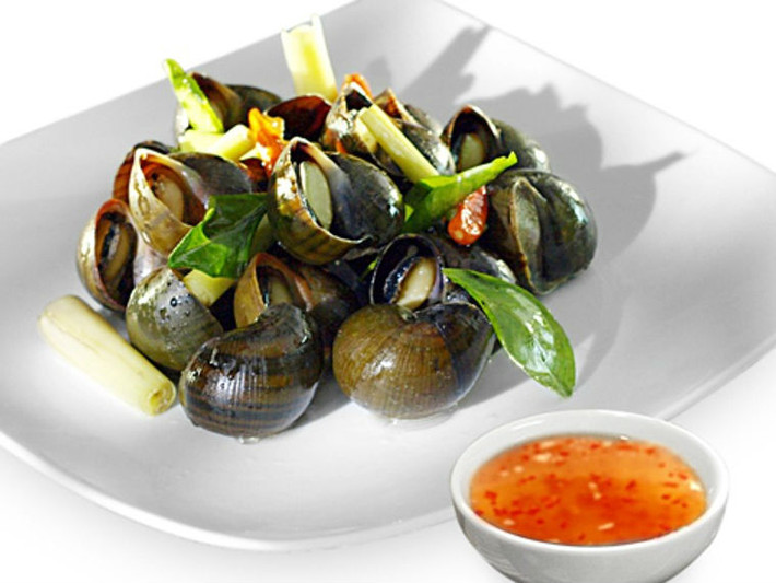 5. Ốc hấp sả, lá chanh. Nguyên liệu: Ốc bươu, sả, lá chanh, ớt, nước mắm, đường. Ốc bươu rửa sạch, ngâm với nước có thêm 1 trái ớt cắt nhỏ để ốc nhả hết bùn, cát. Sả đập dập, cắt khúc, 1 trái ớt còn lại rửa sạch, cắt khúc hoặc sợi. Tiếp theo, cho ốc bươu vào nồi cùng sả cắt khúc, ớt, lá chanh, nước mắm, đường trắng và 1 lít nước, nấu sôi nhỏ lửa. Hấp ốc trong khoảng 10 phút là được. Tắt bếp, cho món ăn ra đĩa, bạn có thể thêm lá chanh và ớt cắt sợi lên món ăn nếu thích. Ảnh: bepgiadinh.com.