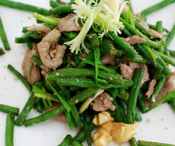 Cho lá lách vào xào cùng dầu ăn trên ngọn lửa lớn cho săn lại, nêm nước mắm, bột ngọt và chút đường, trút ra đĩa. Phi hành tỏi khô băm nhỏ, rồi tiếp đến cho đậu đũa vào xào. Xào cho đến khi đậu vừa chín tới thì trút đĩa lá lách đã xào vào, nêm gia vị vừa miệng, tắt bếp. Rắc hành, ngò, tiêu lên. Ảnh: longlontietcanh.com.