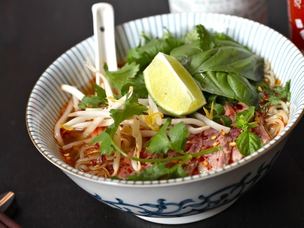 Mỳ "giả" phở: Nấu mì theo hướng dẫn trên bao bì, sử dụng một nửa gói bột nêm. Thêm vào nước dùng 1 quả chanh vắt, một thìa đường, 2 thìa nước mắm, một nhúm ớt xay. Sau đó, đổ mì với nước dùng vào bát, thêm vào vài miếng thăn bò thái thật mỏng, giá đỗ và rau sống. Ảnh: HaVietfoods.vn.