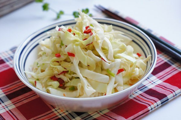 Ớt sừng cắt nhỏ, bỏ hạt, cho vào chén cùng 2 muỗng canh giấm, 2 muỗng canh nước mắm, 1 muỗng canh đường trắng, khuấy đều. Cho bắp cải vào, trộn đều. Cho bắp cải muối vào ngăn mát tủ lạnh, để qua đêm là có thể dùng. Ảnh: NiemDamMe.com.vn.