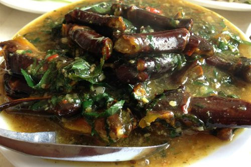 Chắt bớt dầu ăn trong chảo đã chiên sam, thêm hành hương thái mỏng vào đảo thơm rồi cho tỏi vào, khi tỏi thơm thì cho sam vào. Rưới sốt đều lên sam để sốt bám đều. Cho thêm lá lốt thái nhỏ, đảo đều, tắt bếp. Ảnh: nhahangconfetti.com.vn.