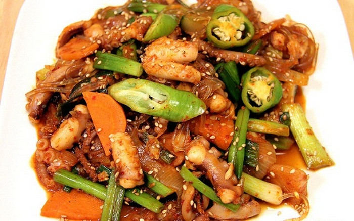 Trộn bột ớt với đường, nước tương, dầu mè, tiêu và tỏi băm. Làm nóng chảo và xào cà rốt, thêm hành tây, hành lá, ớt xanh vào xào trong khoảng 3-5 phút. Thêm bạch tuộc vào chảo rau xào và đổ gia vị đã trộn vào nấu thêm 3 phút trên lửa lớn. Nêm thêm một chút muối nếu cần và rắc thêm vừng rang. Ảnh: Toinayangi.