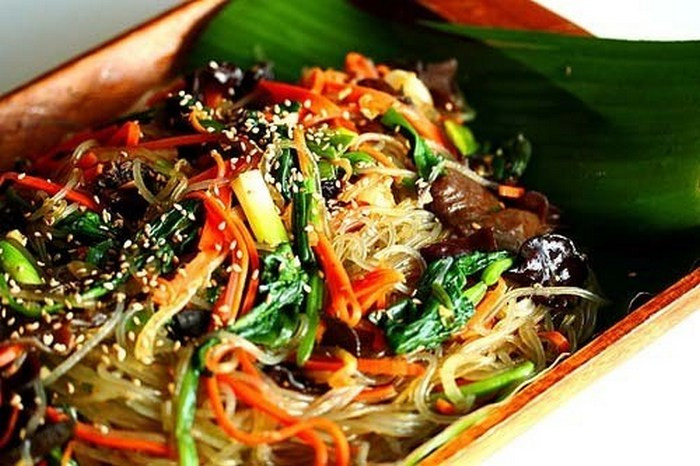 Cà rốt, hành tây, nấm thái sợi, hành lá thái nhỏ, băm tỏi nhỏ. Rau cải xoăn chần qua nước sôi. Thịt bò cũng cắt sợi như cọng tăm rồi ướp gia vị và xào sơ qua. Cho dầu vào chảo phi thơm tỏi và cho rau củ và nấm vào xào. Nêm vừa miệng thì cho miến và rau cải xoăn vào xào, cuối cùng là cho thịt bò vào trộn đều. Rắc hành lá, mè lên cho thơm là đã được món xào kiểu Hàn ngon tuyệt. Ảnh: Laodong.