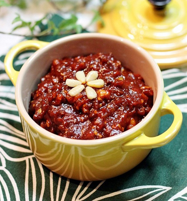 Cho thịt bò xào trong 1 phút rồi cho tương ớt vào xào, thêm nước ép hành tây đun sôi trên lửa vừa trong 5 phút. Tiếp theo, cho óc chó, hướng dương, hạnh nhân, hạt bí ngô cắt nhỏ vào đảo đều khoảng 2 phút. Thêm hạt mè vào trộn đều. Cuối cùng, cho dầu mè và mật ong trộn đều đun thêm 2 phút rồi tắt bếp. Ảnh: Dulichhanquoc.